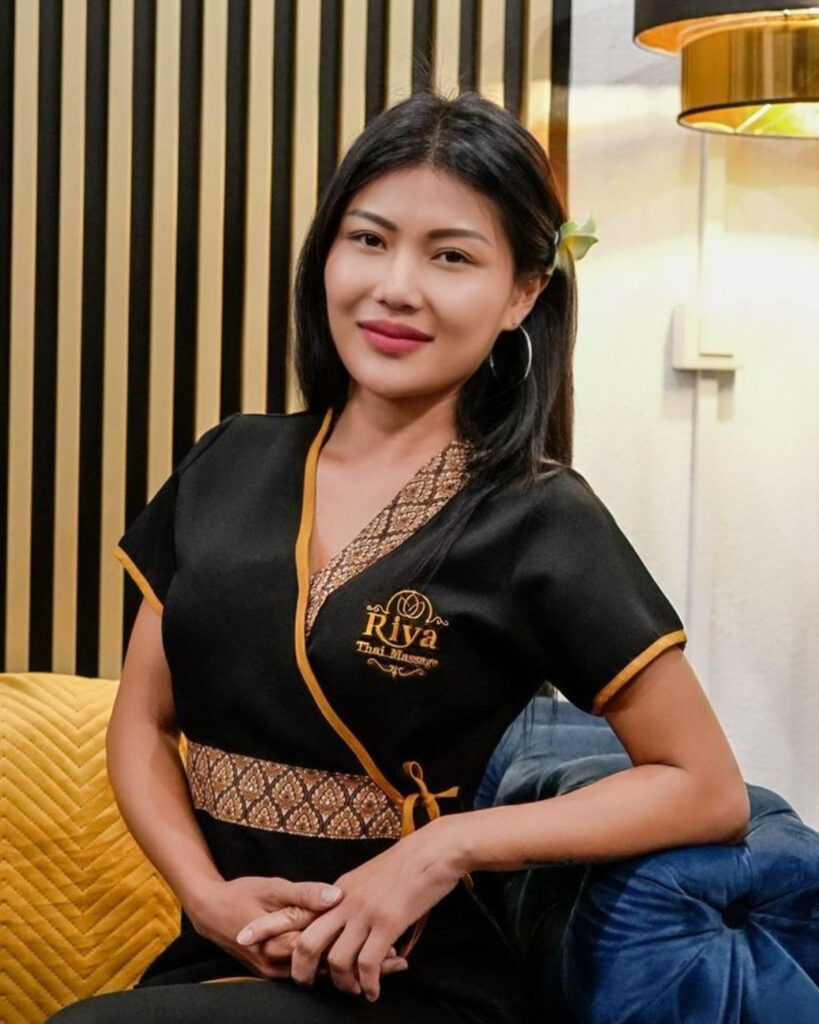 Native Thai therapist smiling Professional Thai massage therapist at Riya Thai Massage Oerlikon, welcoming clients with traditional Thai greeting